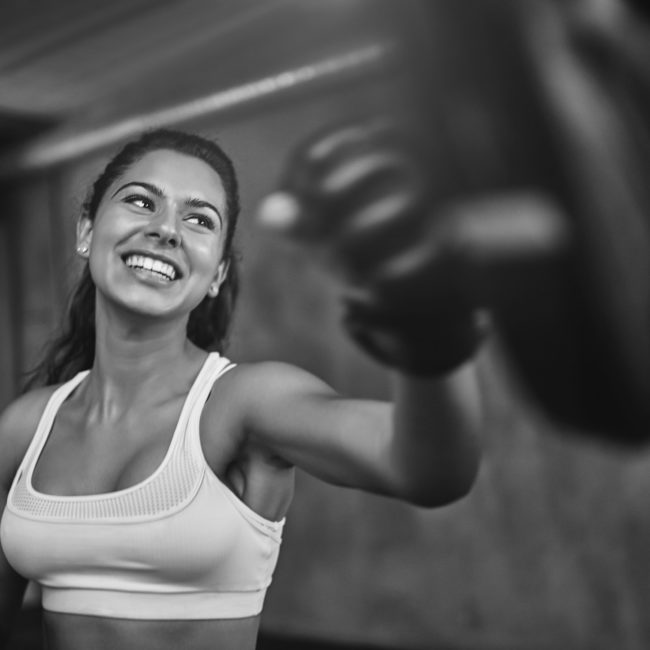 Shot of a young woman sparring with a boxing partner at the gym